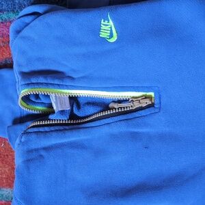 Nike half zip unisex S blue with neon green lettering.